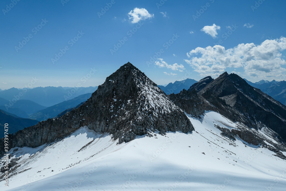 A panoramic view on a glacier, in the nearby of Hohe Sonnblick in Austrian Alps. The high and steep peaks are very sharp. Many mountain chains in the nearby. Clear and sunny day. Mountainerring