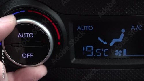 hand changes the temperature of the climate control in the car. hotter colder. photo