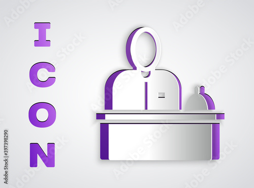 Paper cut Receptionist standing at hotel reception desk icon isolated on grey background. Paper art style. Vector.