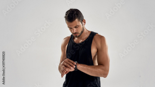 Young handsome caucasian sportsman looking at smart clock