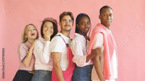 Portrait of young diverse people leaned on each other isolated on pink background, beautiful african asian and caucasian people look at camera. Diagonal horizon photo