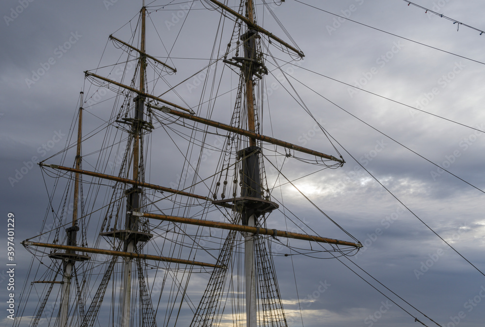 Masts of a large sailing ship with a cloud covered sky background. Masts of a large sailing ship with a cloud covered sky background.