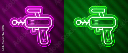 Glowing neon line Ray gun icon isolated on purple and green background. Laser weapon. Space blaster. Vector.
