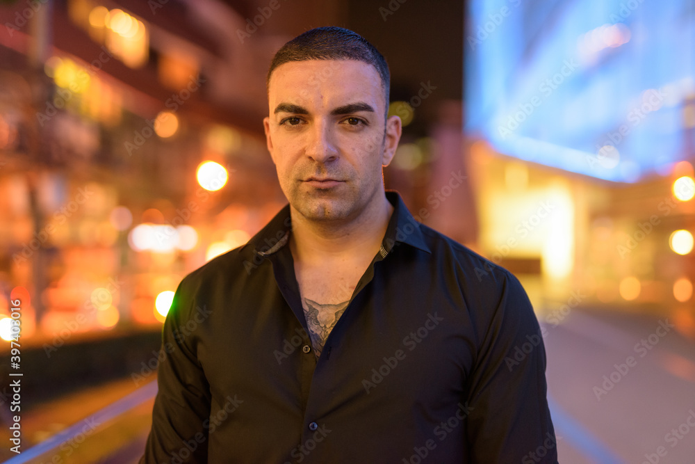 Portrait of handsome man with short hair outdoors at night in city Portrait of handsome man with short hair outdoors at night in city