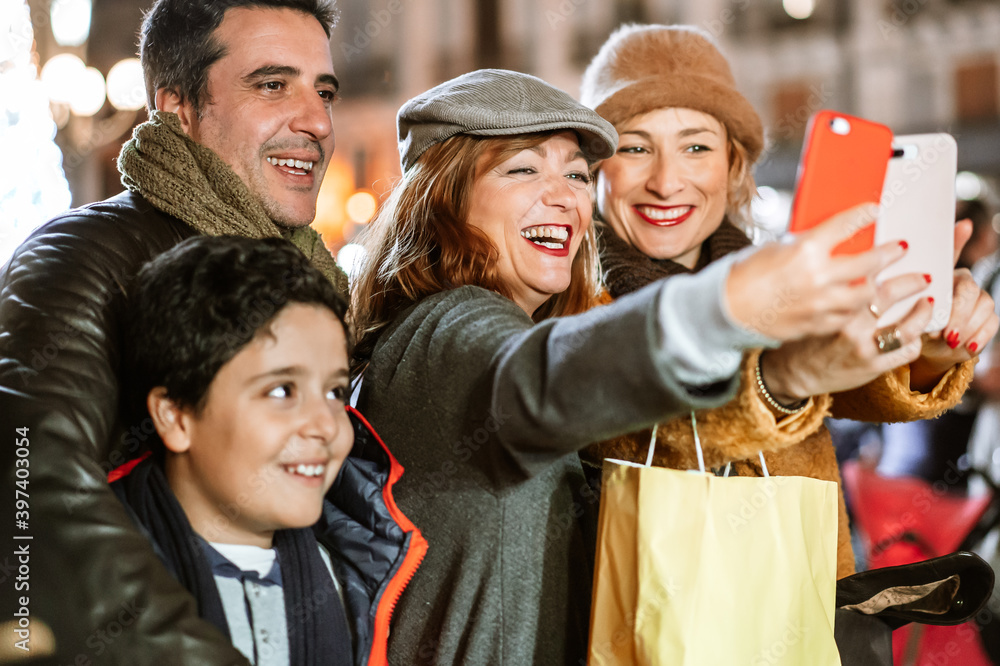 Obraz premium Happy family taking selfie at the local Christmas Market outdoors. .