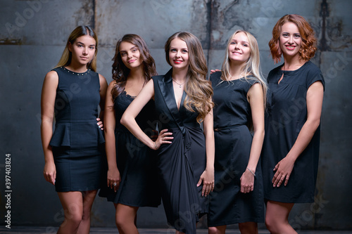 Pretty team. Group portrait of gorgeous young women in black dresses.