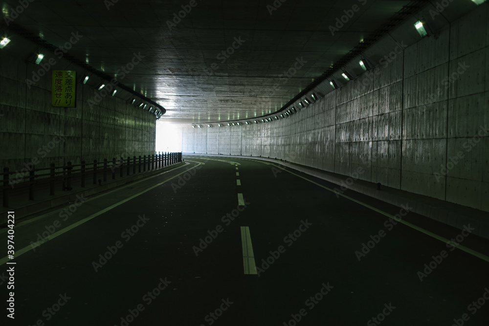 薄暗いトンネルと出口の光