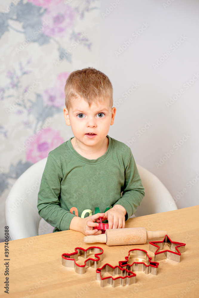 A young boy is getting ready for Christmas. Gingerbread baking A young boy is getting ready for Christmas. Gingerbread baking