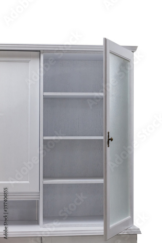Open door of a white wooden kitchen cabinet with shelves.