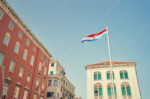 National croatian flag against sky. Beautiful cityscape postcard with Split town architecture.