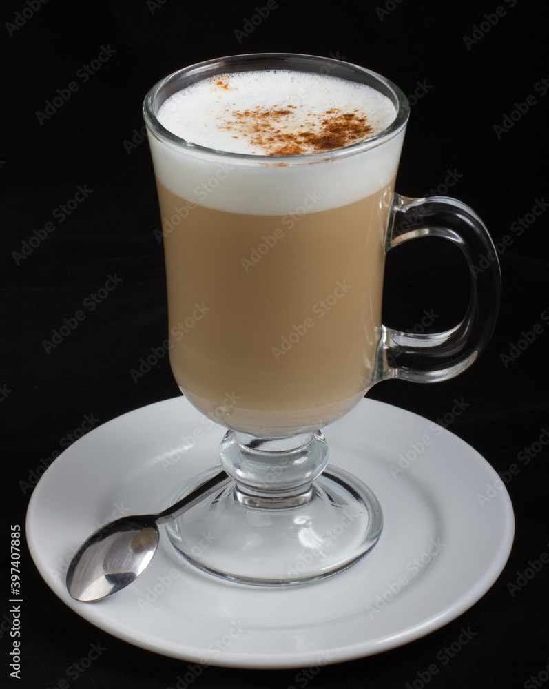 Cappuccino with cinnamon in a glass glass