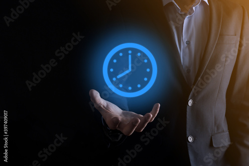 Wallpaper Mural Businessman hand holds the icon of hours clock with arrow. Rapid execution of the work.Business time management and business time is money concepts Torontodigital.ca