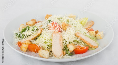 Caesar salad with chicken on a white plate