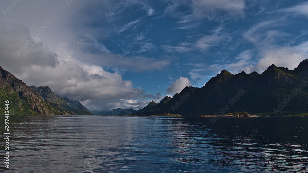 Beautiful panorama view of Raftsundet strait between Austvågøya, Lofoten and Stormolla island in northern Norway with peaceful water and majestic mountains on sunny summer day with some clouds.