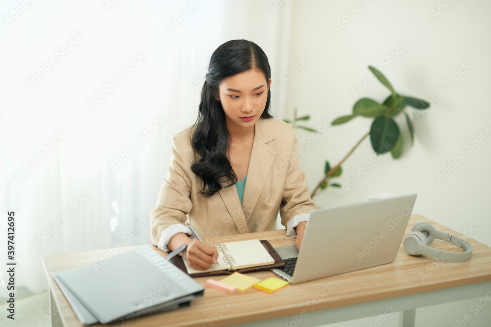 Asian businesswoman mother working at home with notebook computer. Concept for home based work. Asian businesswoman mother working at home with notebook computer. Concept for home based work.