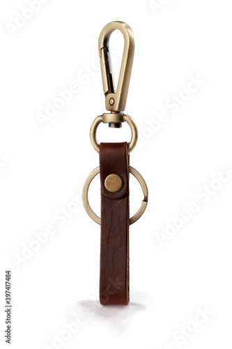 Detail shot of keychain with brown leather belt loop, snap fastener, bronze rings and lobster clasp. The stylish keyring is isolated on the white background. photo