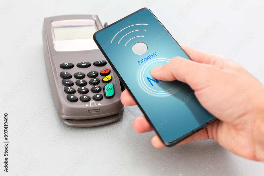 Man using NFC technology on smart phone to pay bill Man using NFC technology on smart phone to pay bill