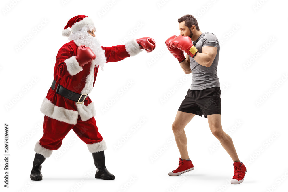 Full length profile shot of a young man and santa claus fighting with boxing gloves