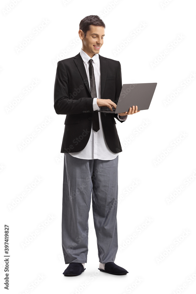 Young modern businessman in a suit and pajamas working on a laptop