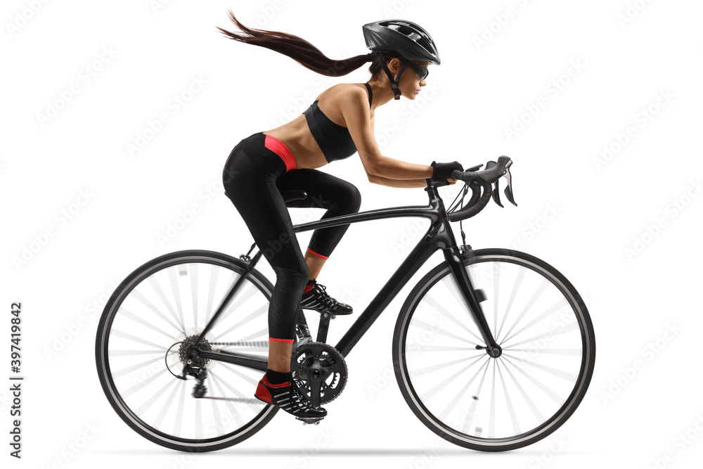 Obraz premium Full length profile shot of a female cyclist riding a road bike