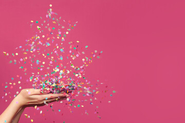 Christmas tree from falling confetti on woman hands against bright pink banner background