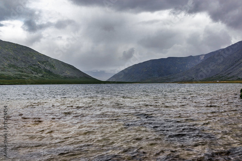 cold lake and mountain range on a rainy day