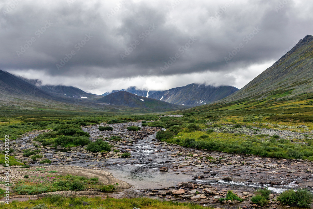 cold stream and mountain range on a summer day cold stream and mountain range on a summer day
