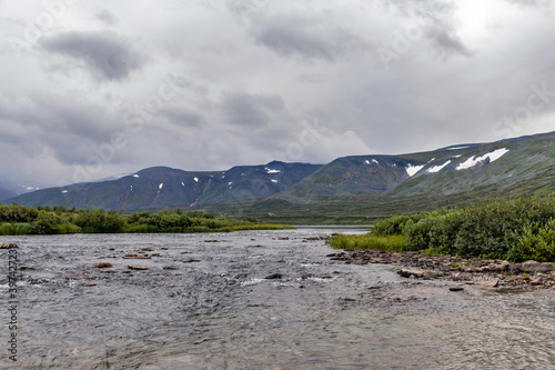 cold stream and mountain range on a summer day