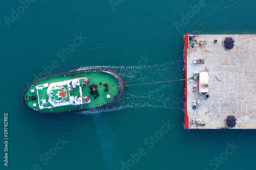 Tugboat pulling a large Barge, Aerial image. © STOCKSTUDIO