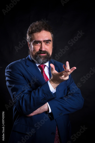 Mature businessman dressed in blue suit with red tie studio portrait.