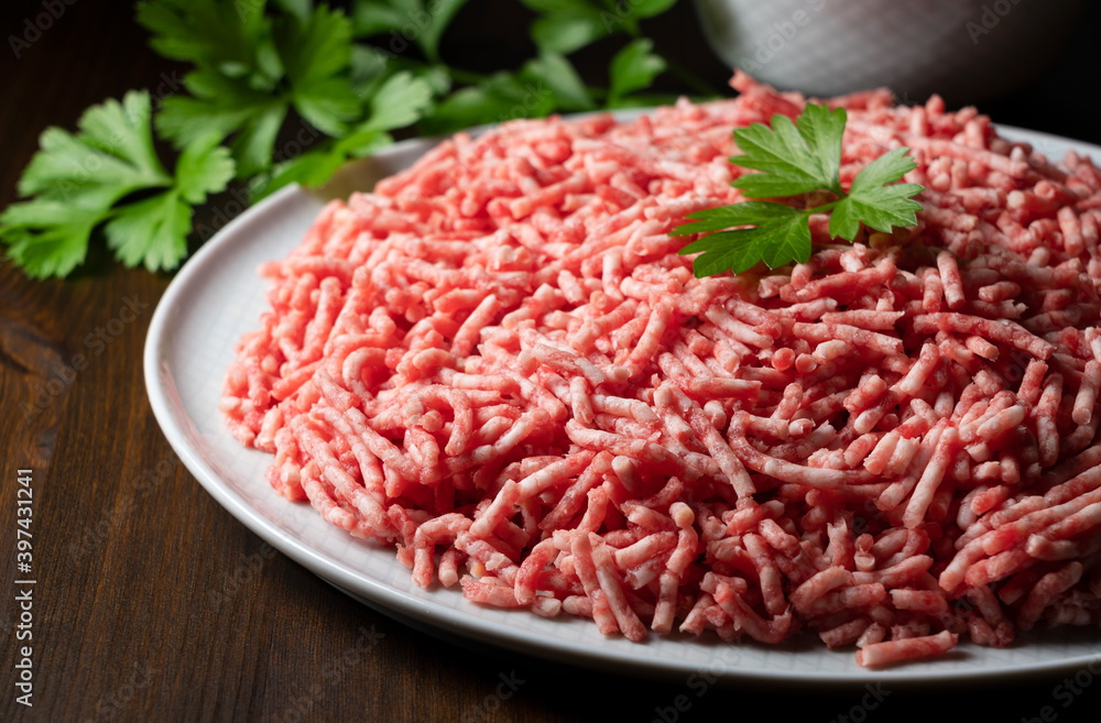Minced meat served on a round plate on a wooden background Minced meat served on a round plate on a wooden background