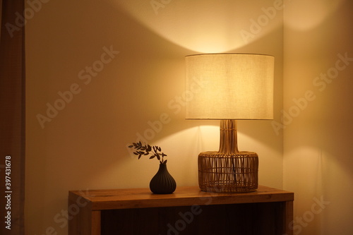 View of a cozy decorative corner with a table lamp spending warm light photo