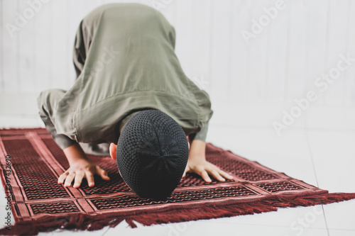 Vászonkép Portrait of asian Muslim Boy wearing traditional costume is doing Salat with pro