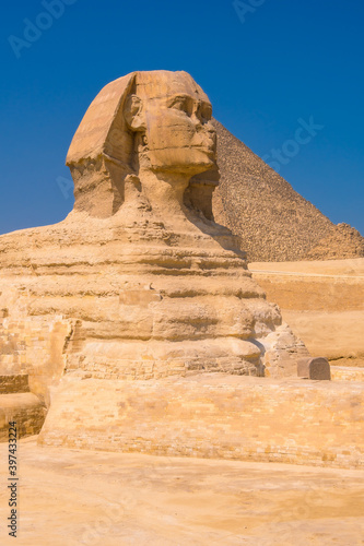 The Great Sphinx of Giza and in the background the Pyramids of Giza  the oldest Funerary monument in the world. In the city of Cairo  Egypt. Vertical photo