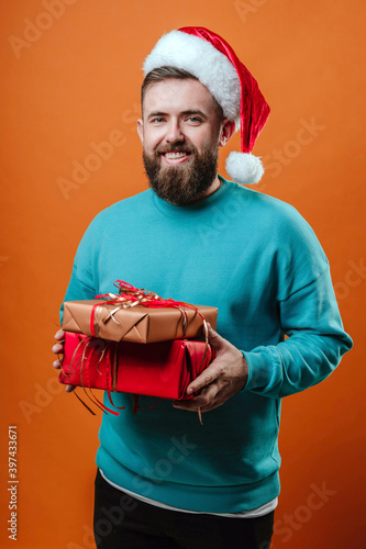 Bearded man Bearded man with santa claus hat and gifts in handswith santa claus hat and gifts in hands photo