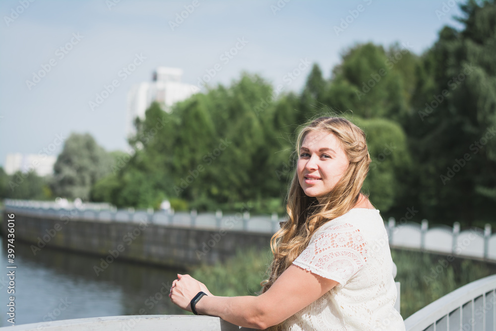 Beautiful pregnant girl in a white dress in a city