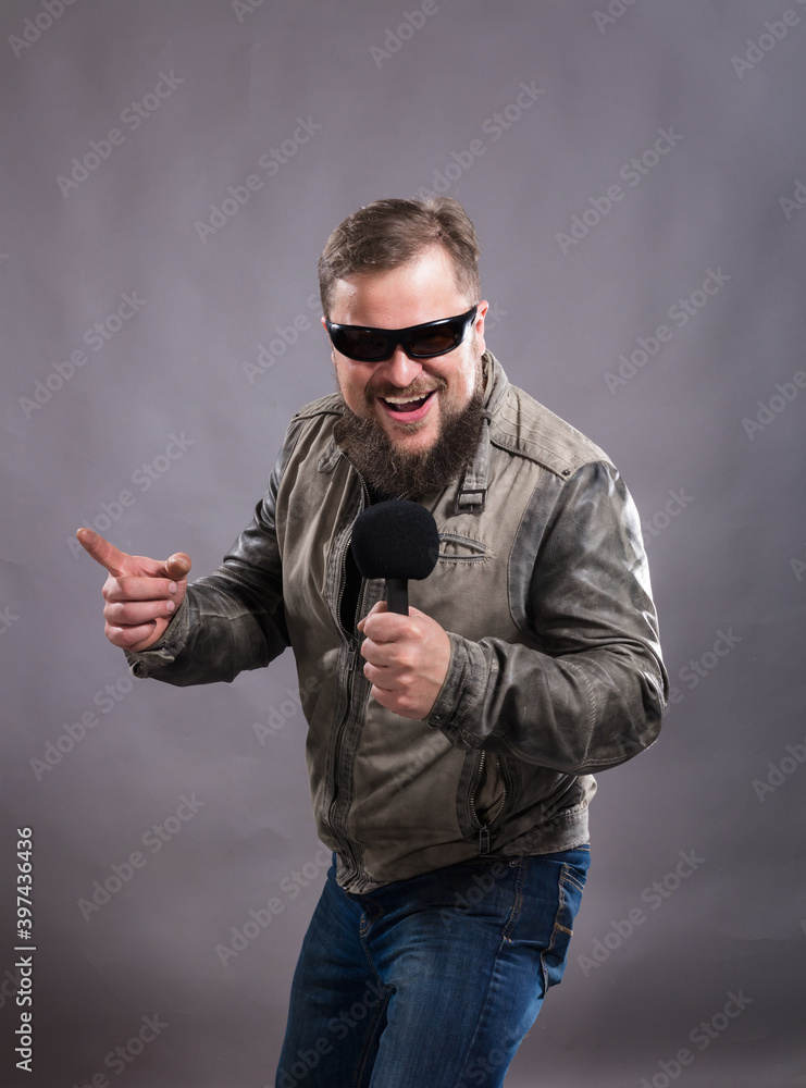 Fototapeta premium Bearded emotional rock singer with microphone studio portrait.