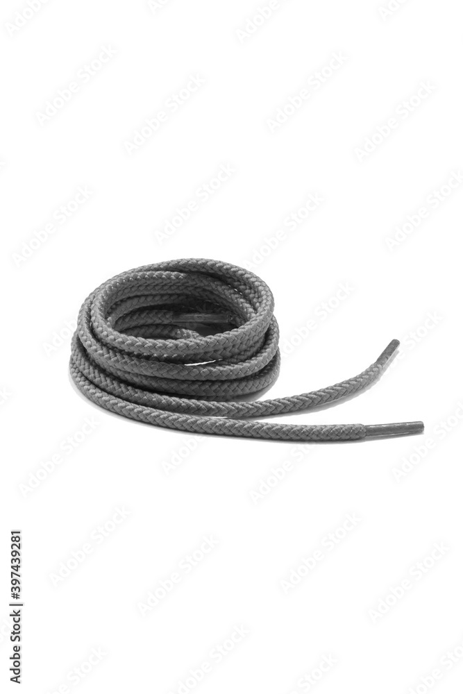 Naklejka premium Subject shot of gray shoe strings with thin tips. The shoe laces are rolled into a coil and isolated on the white background.