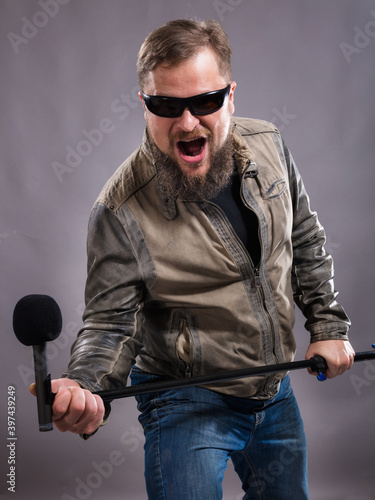 Bearded emotional rock singer with microphone studio portrait. photo