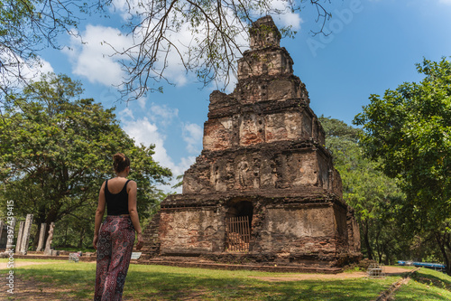young woman is visiting beuatiful temple in archeological site of Polonnaruwa, Sri Lanka