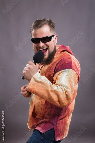 Bearded emotional rock singer with microphone studio portrait.