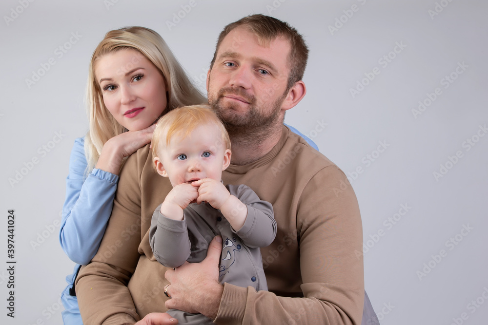 On a gray background family of three people mom dad and baby. On a gray background family of three people mom dad and baby.