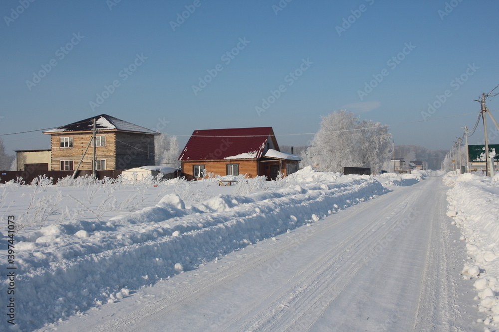 winter in Siberia snow white road in snowdrifts beautiful houses in the village of rime