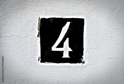 4, number 4, black tile on a white background, vignetted.