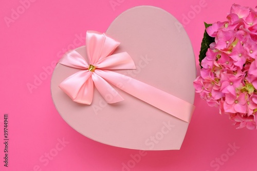 Valentine's day holiday. Gift heart. Pink heart box with pink bow and pink hydrangea on a bright fuchsia background.Love concept.Valentine's Day gift.Mother's day,Wedding day, birthday,women's day
