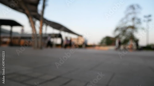 Blurred people walking on walkway with sunset in twilight.