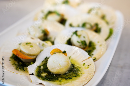 selective focus, Seared scallops shell with butter, garlic and parsley on white plate.