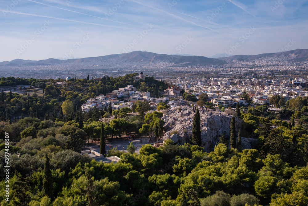 Beautiful scenic city view of Athens shot from Acropolis hill, Greece. Famous Acropolis is the main landmark of Athens. Landscape photo of Athens city from above  from viewpoint on a sunny summer day.