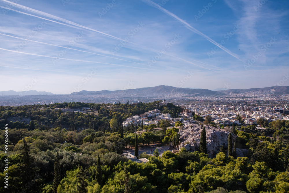 Beautiful scenic city view of Athens shot from Acropolis hill, Greece. Famous Acropolis is the main landmark of Athens. Landscape photo of Athens city from above  from viewpoint on a sunny summer day.