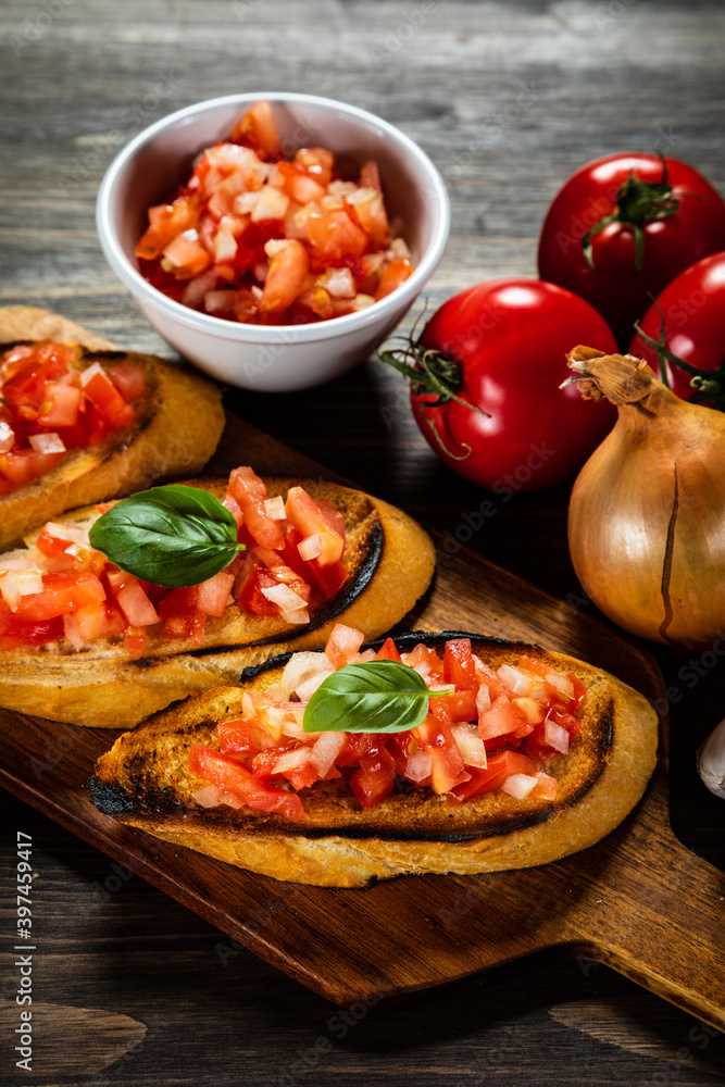 Bruschetta with ingredients on cutting board on wooden background
Bruschetta with ingredients on cutting board on wooden background